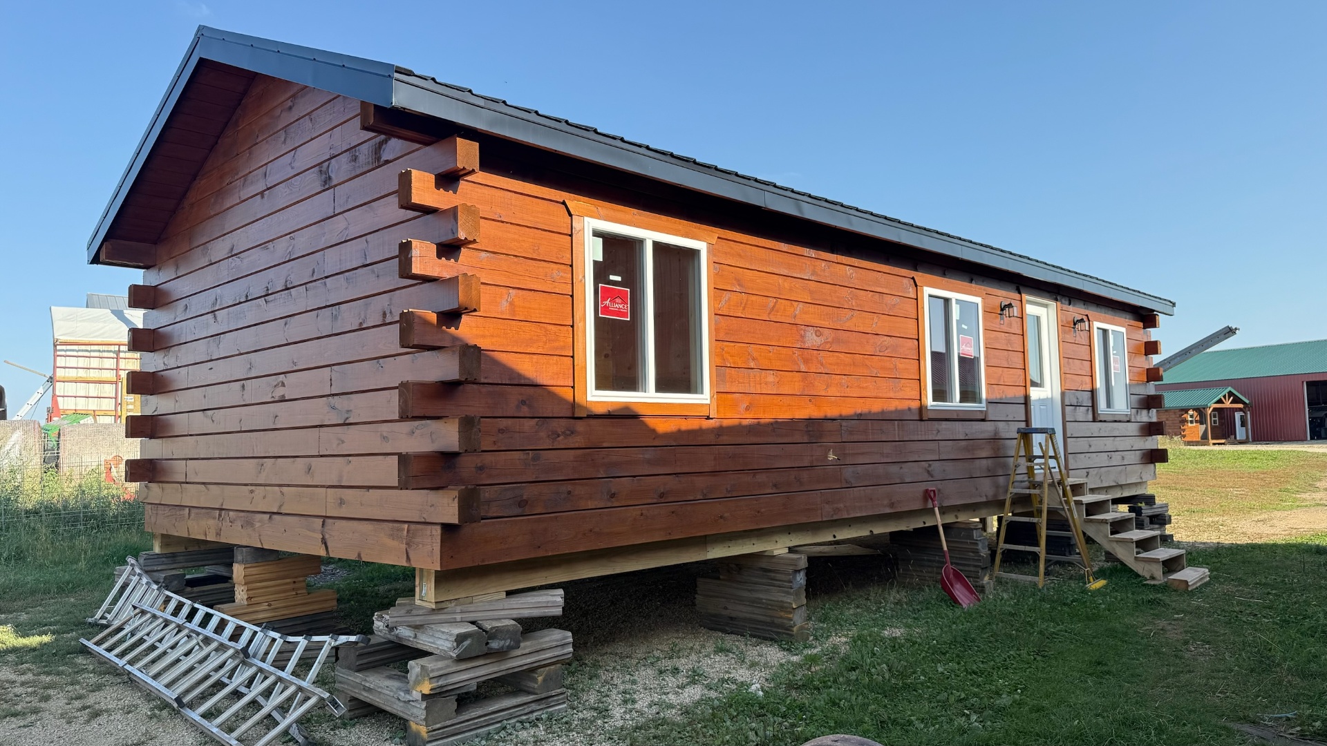 Stained single-level log cabin exterior on display lot