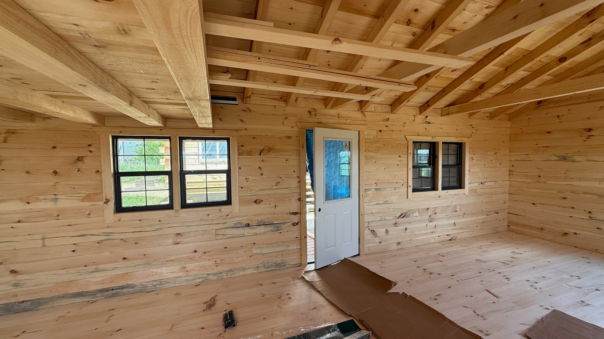 Open pine cabin interior with black windows