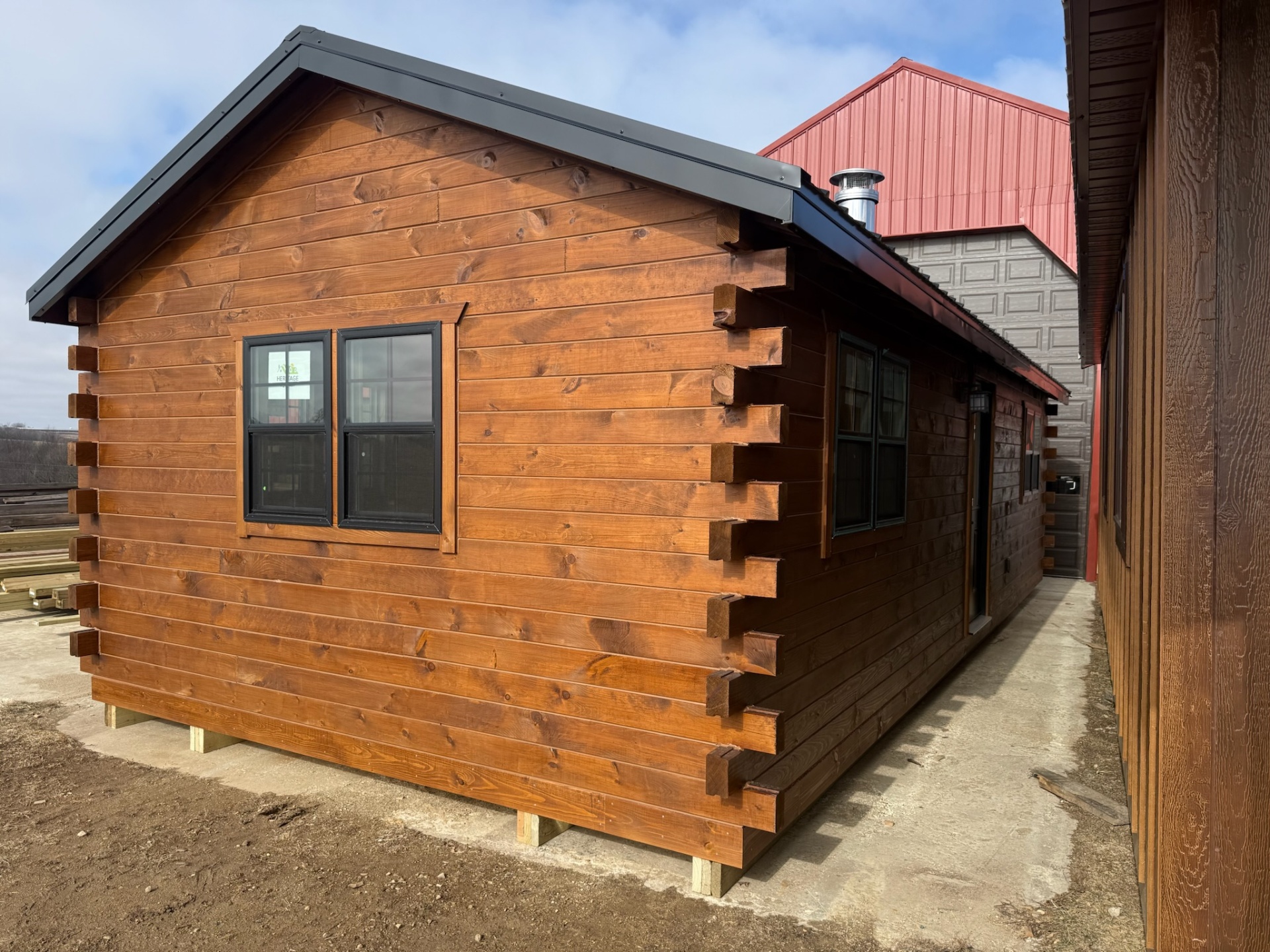 Stained pine mini cabin with black metal roof